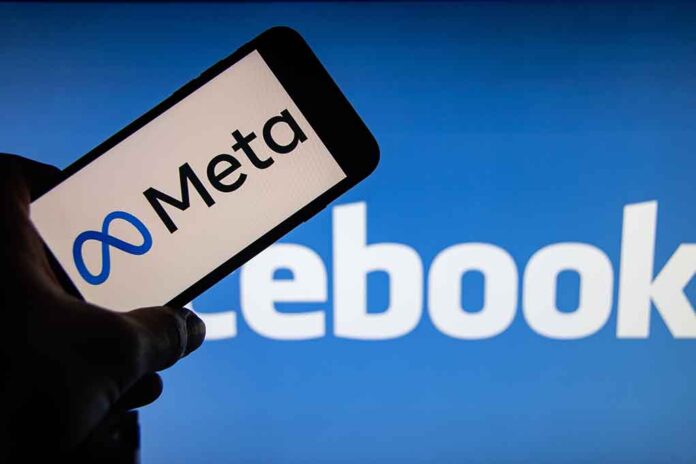 Meta logo on phone, Facebook logo in background.