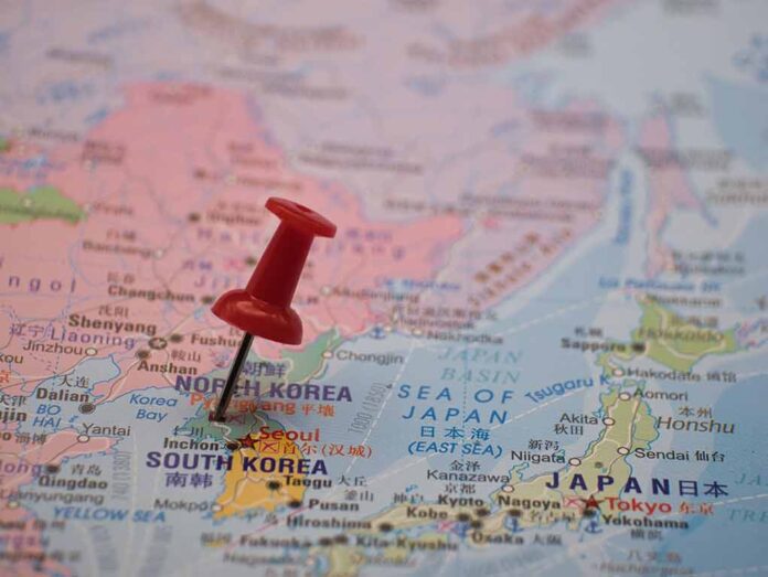 Red pushpin marking Pyongyang on a world map.