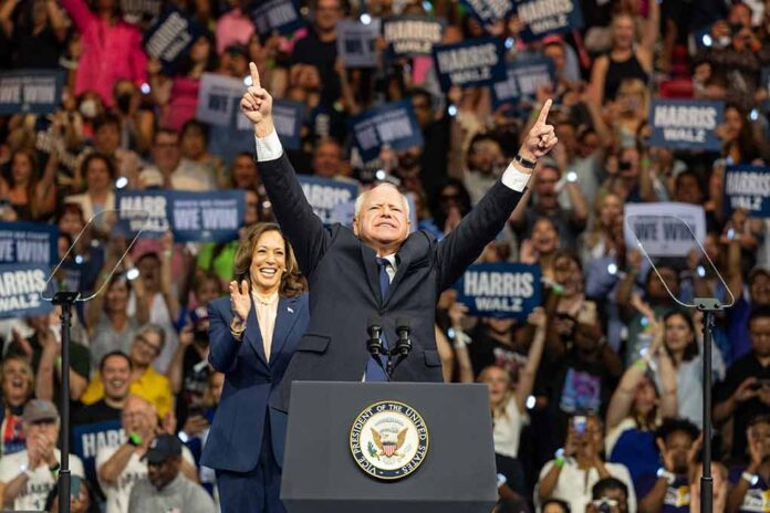 Politicians at a rally, crowd in the background cheering.