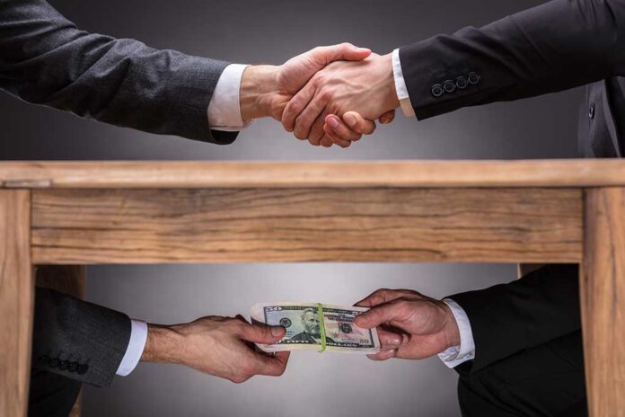 Handshake above table, money exchanged below.