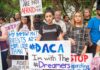 People protesting with signs supporting DACA and Dreamers.