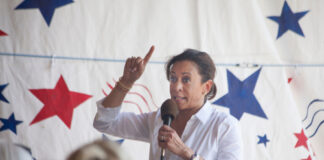 Unknown woman speaking and gesturing at a political event.