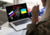 Laptop displaying ATTACK with Russian and Ukrainian flags