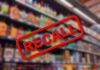 "Recall sign over blurred grocery store shelves."