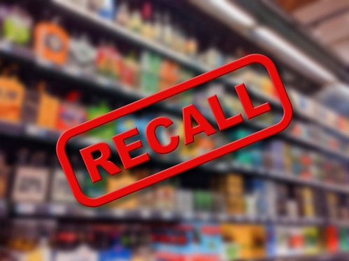 "Recall sign over blurred grocery store shelves."