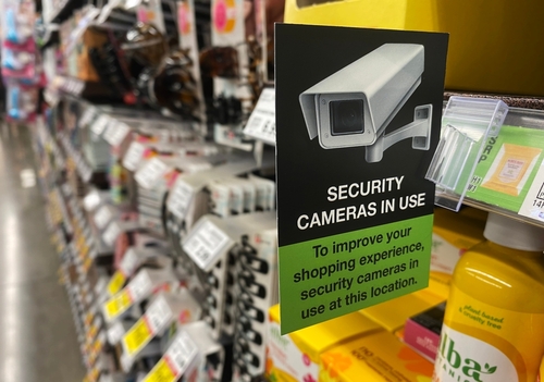 Aisle with a security camera sign and products.