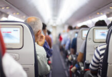 People seated inside an airplane cabin.