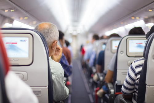 People seated inside an airplane cabin.