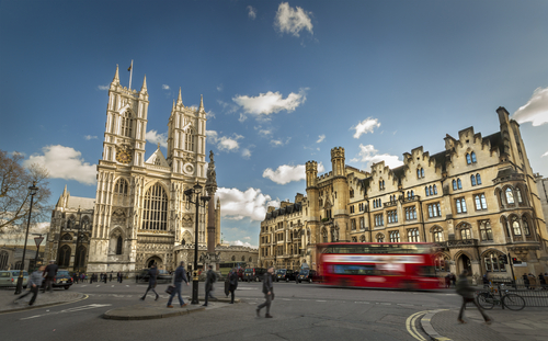 Westminster Abbey with passing red double-decker bus.